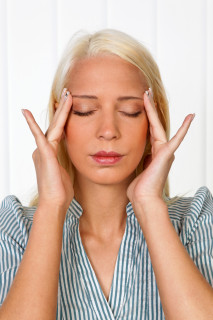 Woman performing self massage for headaches